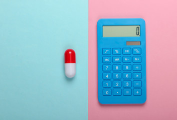 Calculation of the cost of medical expenses. Calculator and pill on a blue-pink pastel background. Top view. Minimalism