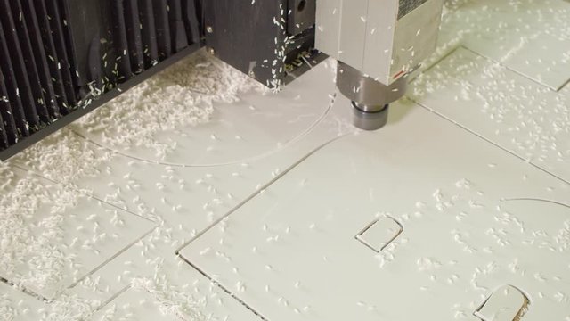 Milling machine cut letters out of white plastic canvas. Production of adv sign