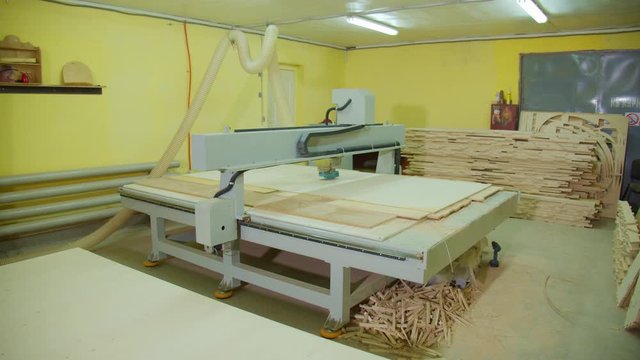 Milling machine with cnc in workshop wood furniture production. Stack plywood.