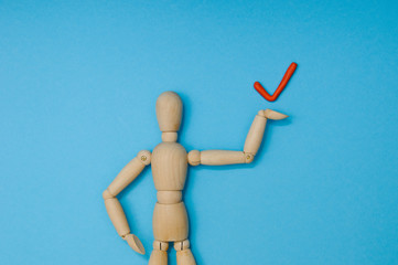 Wooden mannequin with empty miniature shopping cart running for sales on red background. Mockup for shopping, sales, black friday, copy space, side view.