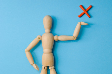 Wooden mannequin with empty miniature shopping cart running for sales on red background. Mockup for shopping, sales, black friday, copy space, side view.