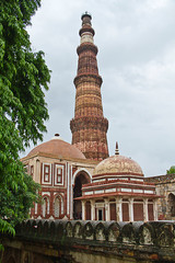 Qutub Minar with a tomb in the foreground, intricate carvings, stone Tower, almost 700 years old world heritage site