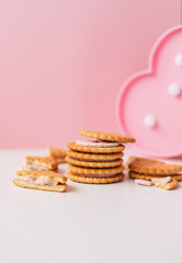 Sweet creamy filling crackers on a white-pink pastel background. 