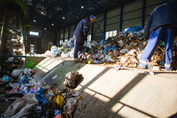 Obraz premium manual sorting of garbage at the factory to receive unsorted garbage