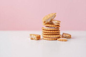 Sweet creamy filling crackers on a white-pink pastel background. 