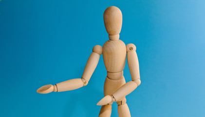 Wooden dummy proudly presents some invisible thing, isolated on white background, copy space for your object or text