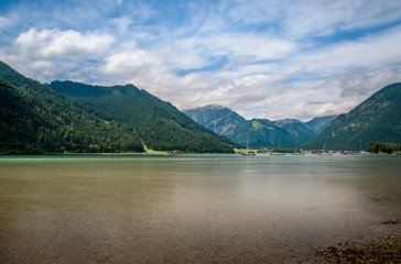 Der schöne Achensee in Österreich ist von den Alpen umgeben und die Touristen gehen schwimmen.