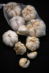 Bulbil, head and net of garlic on a dark background