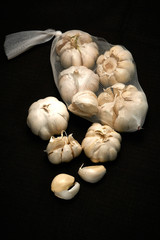 Bulbil, head and net of garlic on a dark background