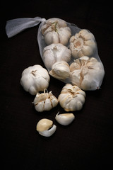 Bulbil, head and net of garlic on a dark background