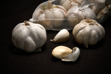 Bulbil, head and net of garlic on a dark background