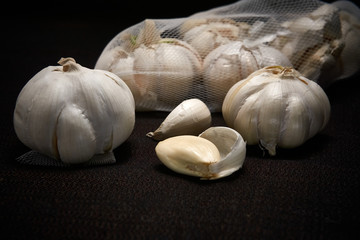 Bulbil, head and net of garlic on a dark background