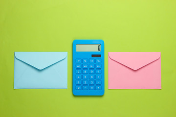 Calculator with envelopes on green background. Top view