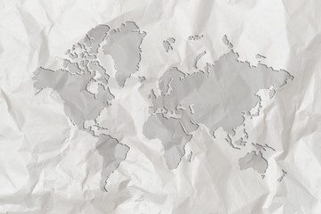 A map of the world is depicted on crumpled white paper.