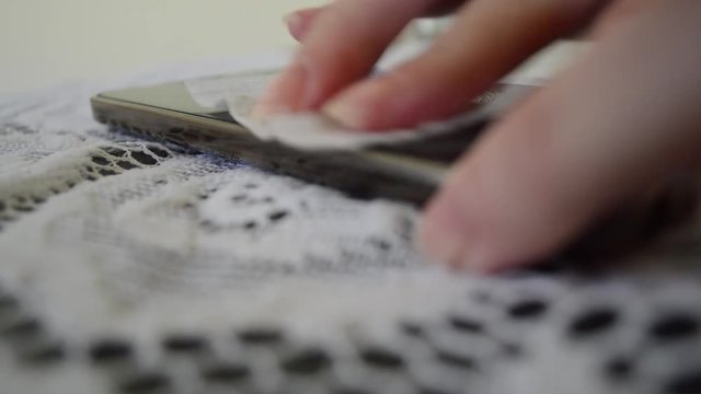 hand cleaning cell phone (smartphone) screen with alcohol gel - virus and bacteria control concept