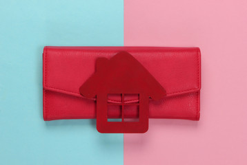 Obraz premium Family budget management. Figurine of a house with wallet on pink blue pastel background. Top view