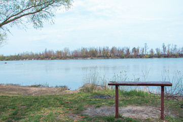 Naklejka na ściany i meble lonely bench on the river side