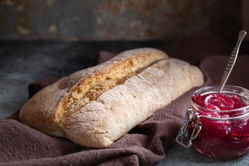 Ciabatta bread. Loaf of bread and jam on dark ambience. Low shallow focus
