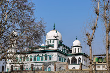 Fototapeta premium Ruins of ancient Hindu temples Avantipur, Jammu and Kashmir. And a beautiful architecture of mosque with clear blue skies in the backdrop captured from temple ruins. Winter trip to Kashmir, India.