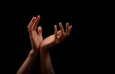 Fototapeta premium Female hands on a black background.