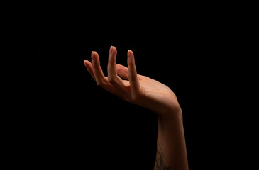 Woman hand on black background. Holding or offering. Outstretched female hand, girl keeping empty palm on black isolated background