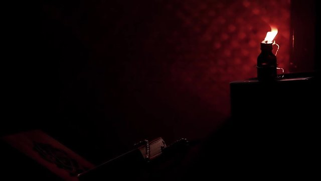 The Quran, the Muslim holy book, with misbaha or the Islamic prayer beads on the rihal or a wooden book stand in a rural room lit by a traditional oil lamp. Ramadan-themed video background.