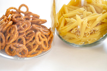 Pasta and oatmeal in glass jars on white background on kitchen.Stocks of non-perishable products on a light background. Organized home simple stylish storage no plastic, zero waste.
