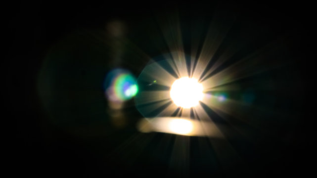 Bright lens flare out of focus with small coloured bokeh.