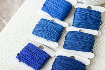 Materials for needlework. Threads for classic blue embroidery. Female hobby. Occupation for women during the quarantine period. Copy space.