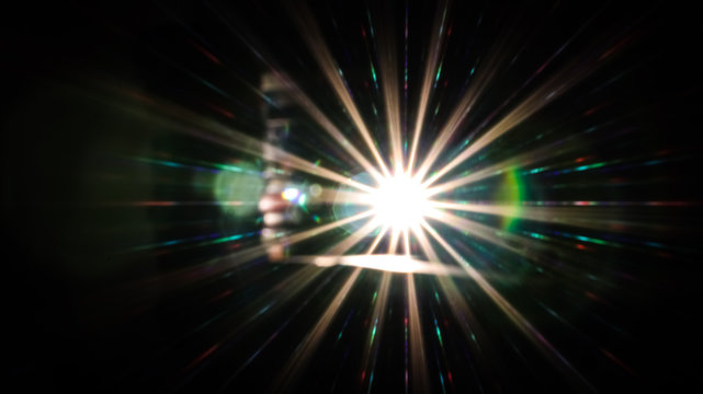 Bright lens flare out of focus with small coloured bokeh.