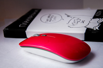 pink wireless mouse near notebook