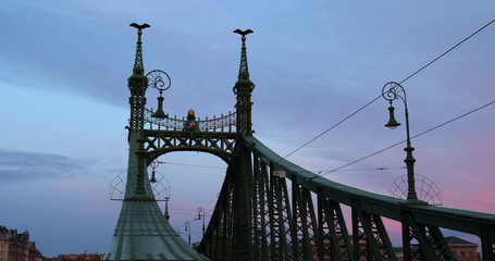 Liberty Bridge with pink sunset sky and a few clouds.