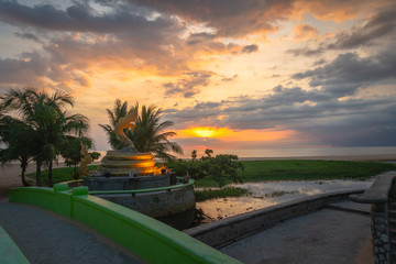 sunset behind the great Naga statue in Karon beach Phuket Thailand