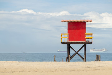 red lifeguard post on copacabana beach with the sea in the background and the blue sky in rio de janeiro.