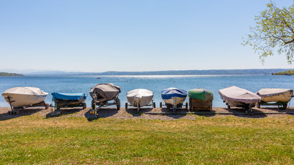 Fototapeta na wymiar Sailboats lined up at the shores of Lake Ammer (Ammersee).