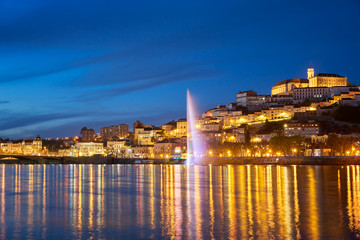 Coimbra city view at night with Mondego river and beautiful historic buildings, in Portugal