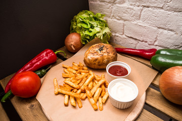 Burger and different vegetables on the wooden table. Flat lay