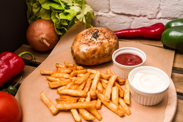 Burger and different vegetables on the wooden table. Flat lay