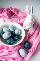 Easter pastries, colored eggs of various colors, Easter bunny on a white, blue and pink background