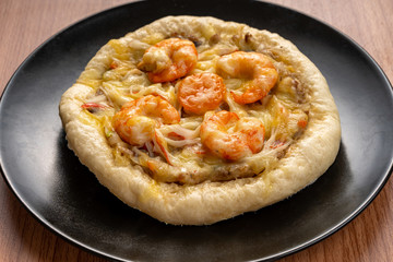 Pizza Cheese with Shrimp, Pork, Imitation Crab Stick and Salted Eggs on White Dish Wood Table.
