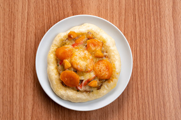 Pizza Cheese with Shrimp, Pork, Imitation Crab Stick and Salted Eggs on White Dish Wood Table.