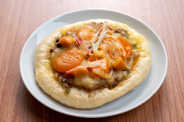 Pizza Cheese with Shrimp, Pork, Imitation Crab Stick and Salted Eggs on White Dish Wood Table.
