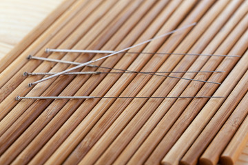 Table with needles for acupuncture. Silver needles for traditional acupuncture medicine on table.