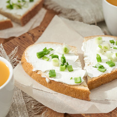 Two sandwiches heart shaped with cream cheese and green onion.