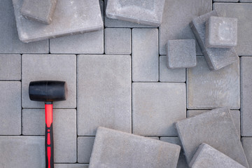 Paving stones paving background. Installing tools rubber hammer on foreground