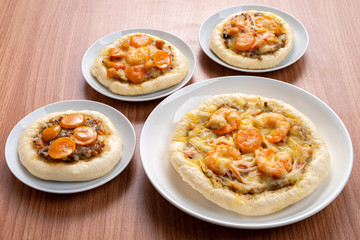 Pizza Cheese with Shrimp, Pork, Imitation Crab Stick and Salted Eggs on White Dish Wood Table.