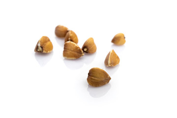 Buckwheat porridge. Brown raw organic seeds isolated on white. Cereal grains on vegetarian food background. Healthy diet superfood with antioxidant, mineral nutrients.