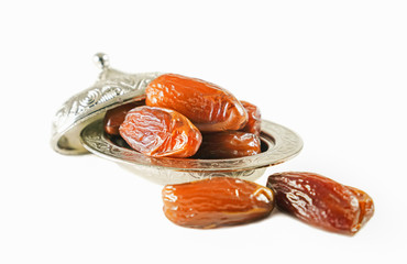 Fresh fruit dates in a silver metal bowl on isolated white background