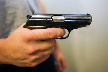 A man holds a gun in his hand threatening.
