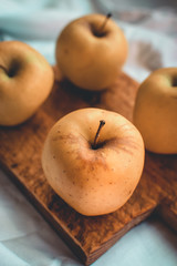 Four apples on a wooden cutting board